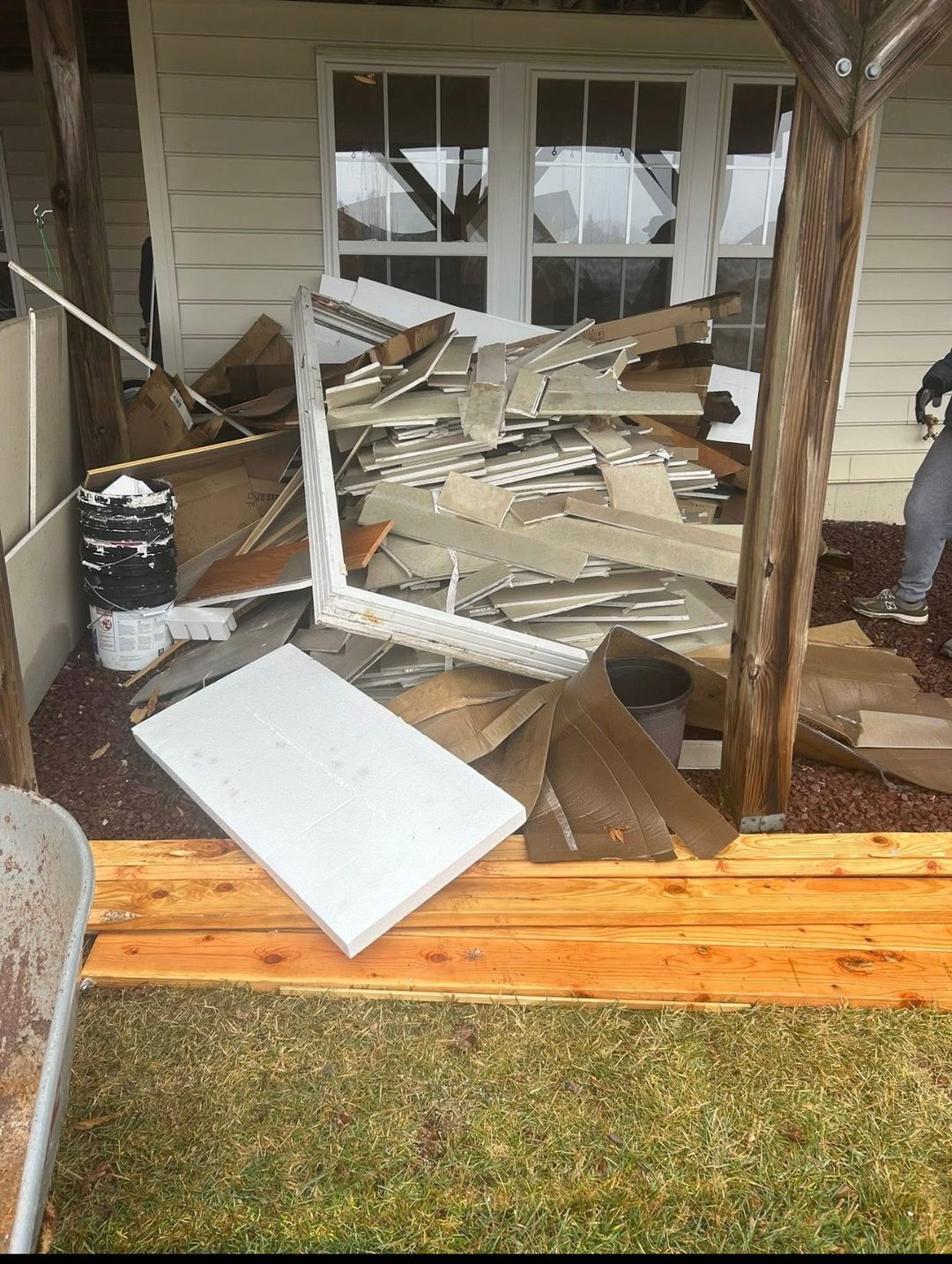 Porch piled with construction debris and insulation before cleanout