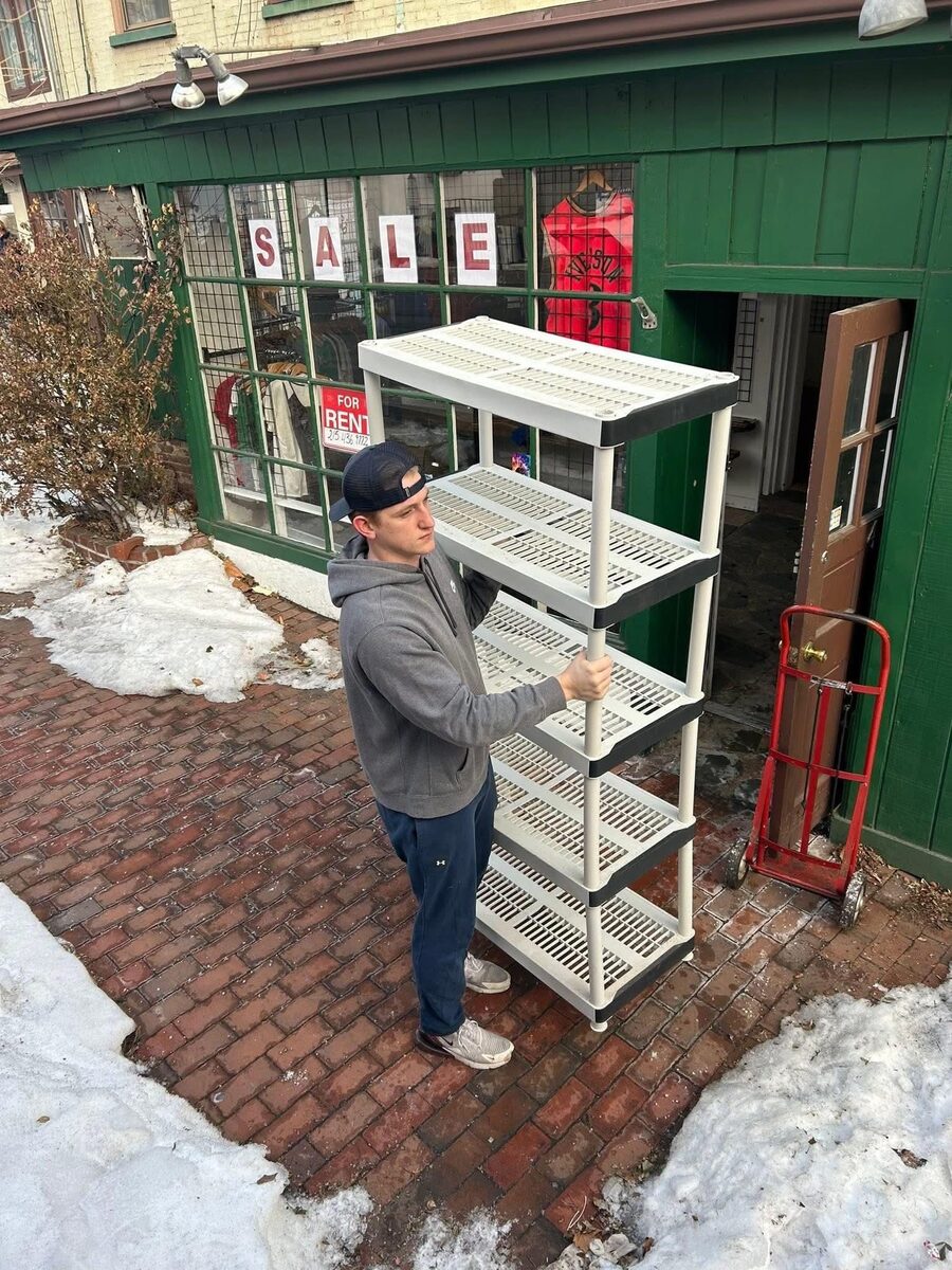 Moodys crew member moving a shelving unit on a junk removal job in Doylestown, Bucks County